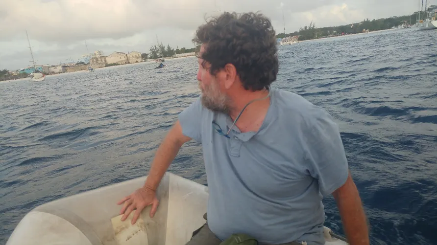 איש צוות יושב על הסיפון מול המים