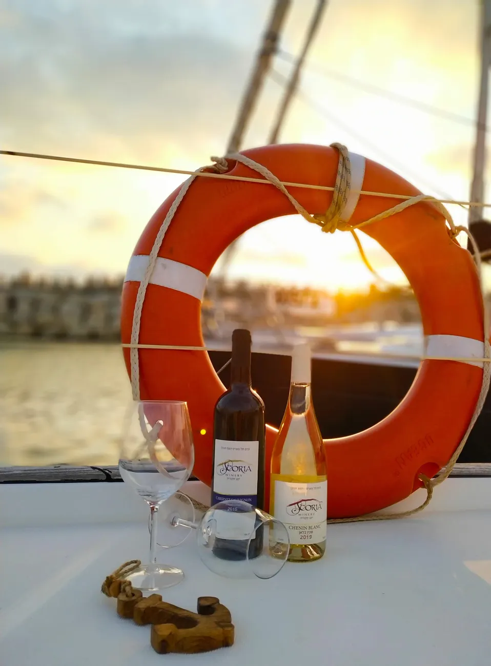 A wine bottle and glass beside a lifebuoy aboard